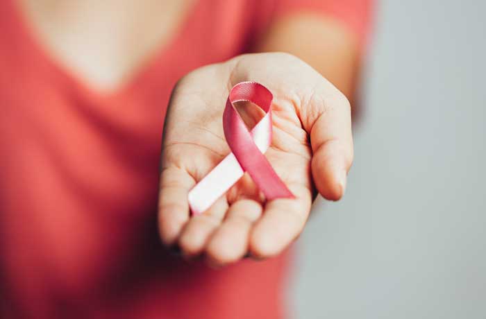 Mujer sosteniendo cinta de concienciación sobre el cáncer