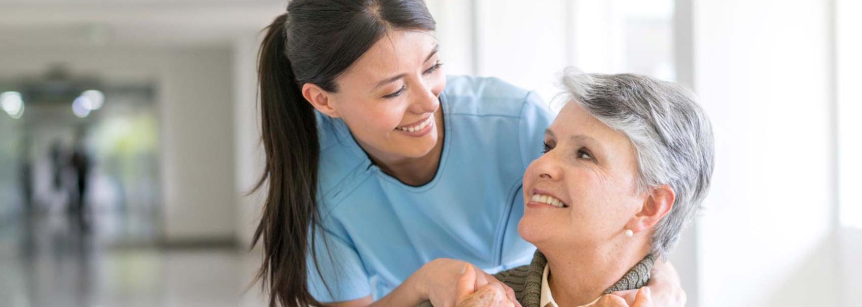 Female nurse and Female patient smiling at each other