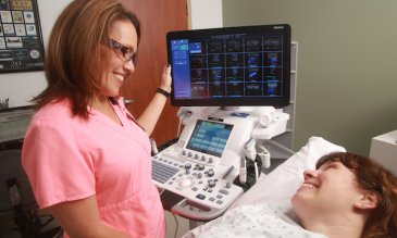 An echocardiography technician with a patient