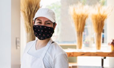 Bakery owner smiling while wearing a mask