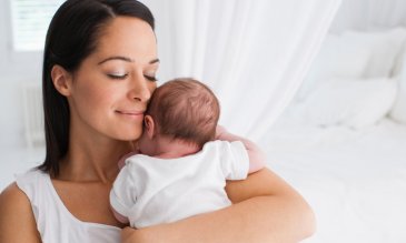 Woman holding her young baby stock photo