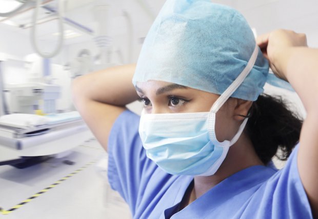 Medical professional putting on mask