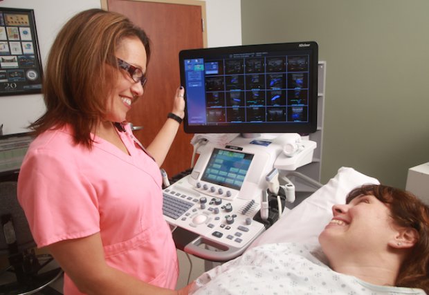 An echocardiography technician with a patient