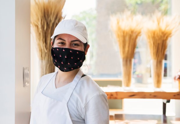 Bakery owner smiling while wearing a mask