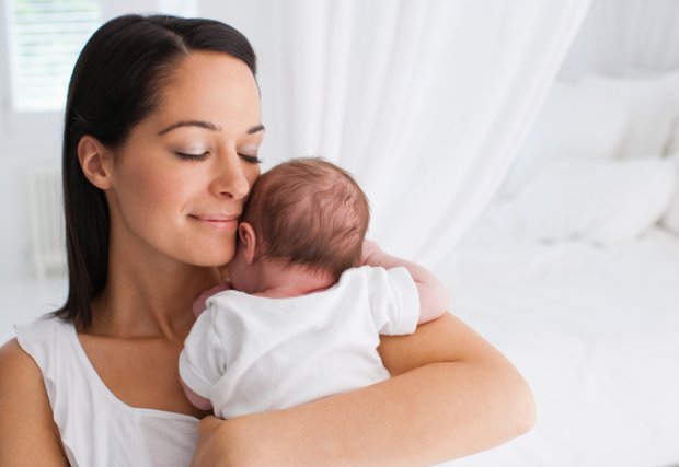 Woman holding her young baby stock photo