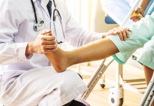 Doctor assessing a patient recovering from a leg injury