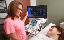 An echocardiography technician with a patient