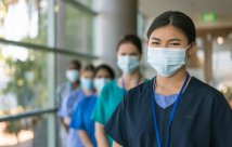 Stock image of five medical professionals wearing masks and smiling at the camera